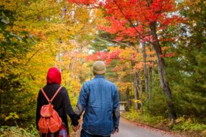 Muslim couple walking together through a scenic forest path, symbolizing love and companionship.