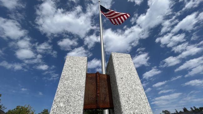 **Alt Text:** "9/11 Memorial in New York City with cascading waterfalls and inscribed names, honoring the victims of September 11, 2001."
