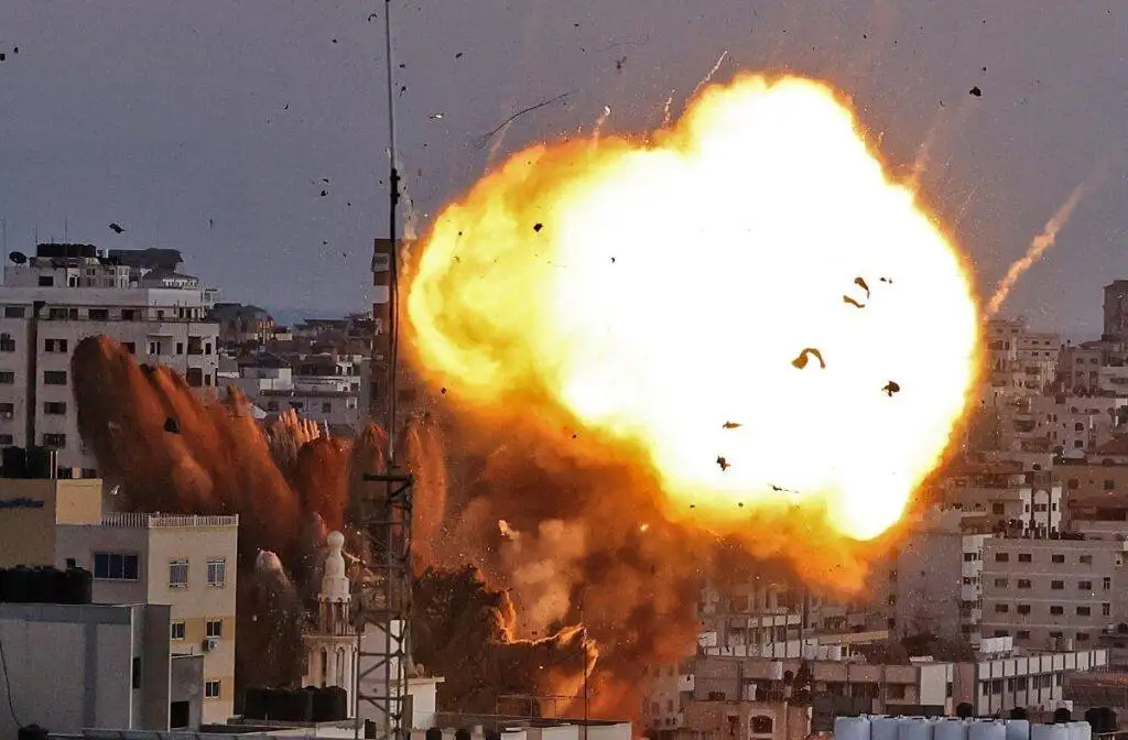 A devastating airstrike in Gaza shows buildings in flames, capturing the human cost of war and ongoing destruction in the region.