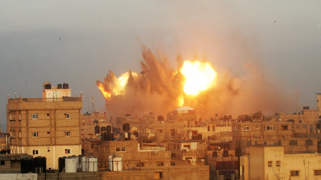 A devastating airstrike in Gaza shows buildings in flames, capturing the human cost of war and ongoing destruction in the region.