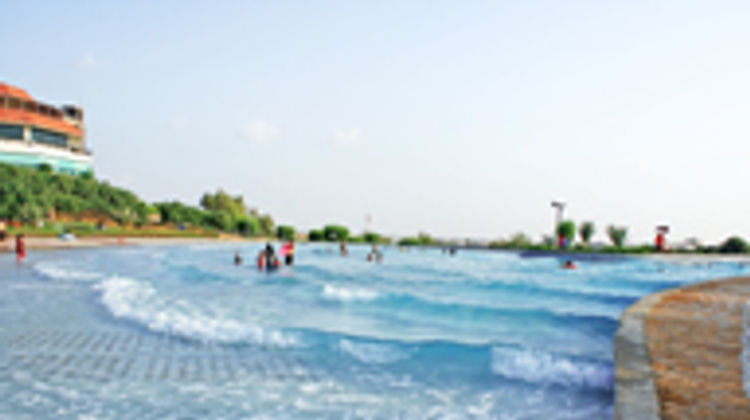 A giant monkey standing near a seaside house with people bathing, representing surreal dream imagery and imagination